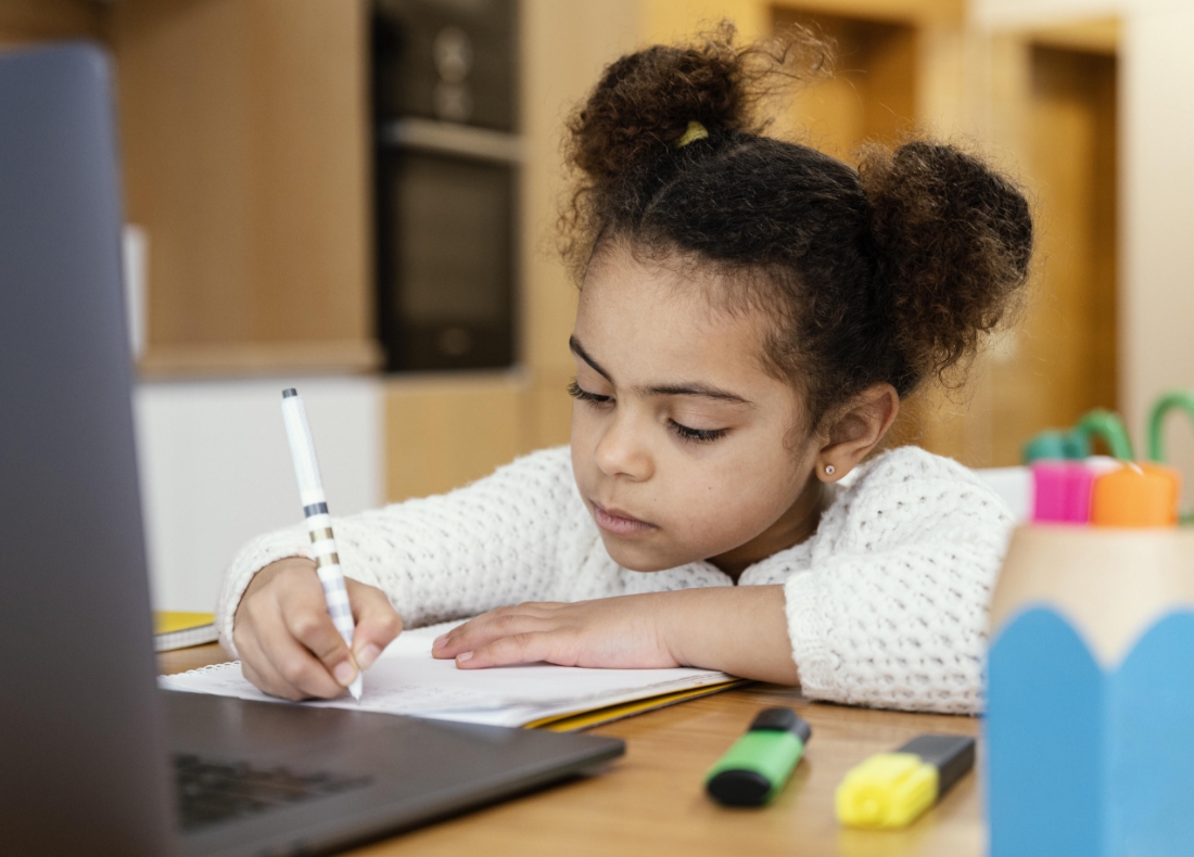 mission image Girl writing on a pad in front of a monitor
